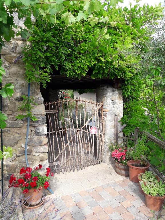 una puerta de jardín con macetas en una pared de piedra en Maison aux Lavandes The Studio, en Vaumeilh