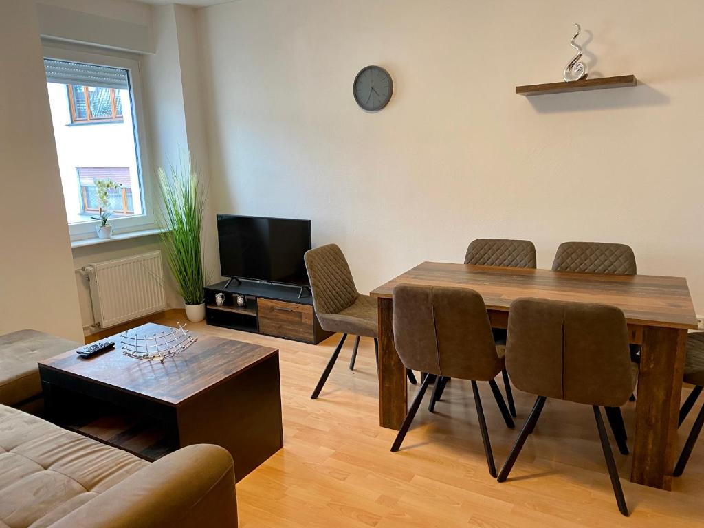 a living room with a wooden table and chairs at Apartments Lissy I und II in Neunkirchen