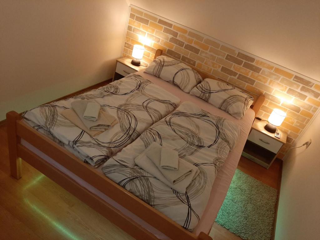 um quarto com uma cama grande e uma parede de tijolos em Apartman Lelly em Novi Lazi