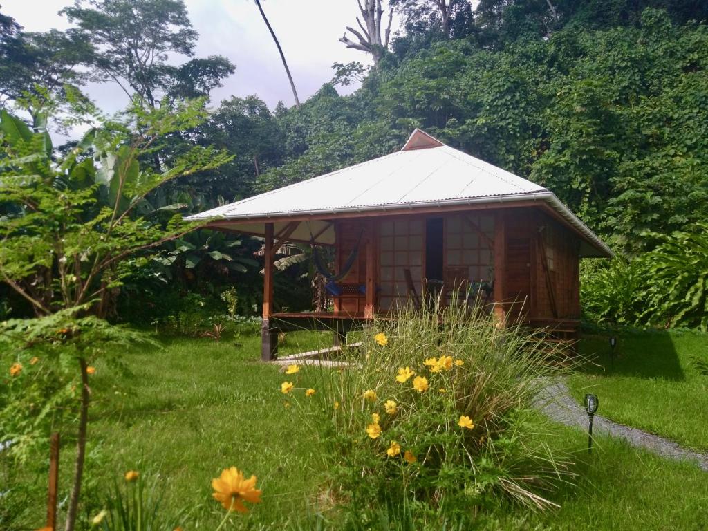 una pequeña cabaña en un campo de hierba con flores en Fare Hanuatai, en Tevaitoa