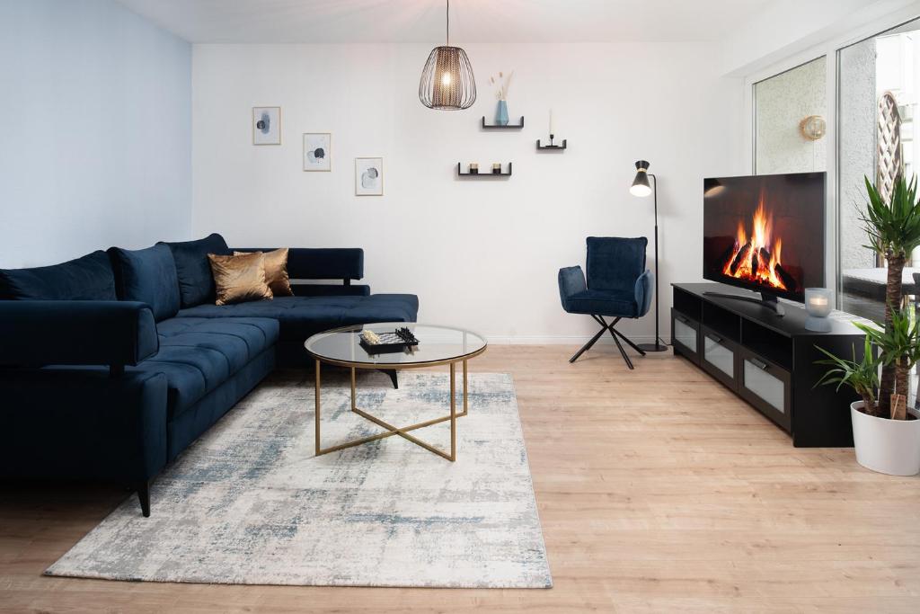 ein Wohnzimmer mit einem blauen Sofa und einem Kamin in der Unterkunft Aparte - Washer & Dryer - Kitchen & Parking - Smart-TV in Sarstedt