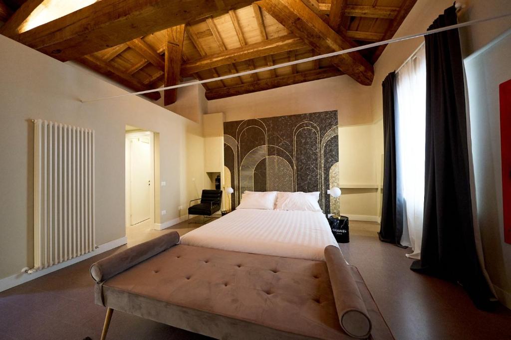 a large bedroom with a large bed and a couch at Ginevra Boutique Rooms - Palazzo Leosini - Residenze D'Epoca in LʼAquila