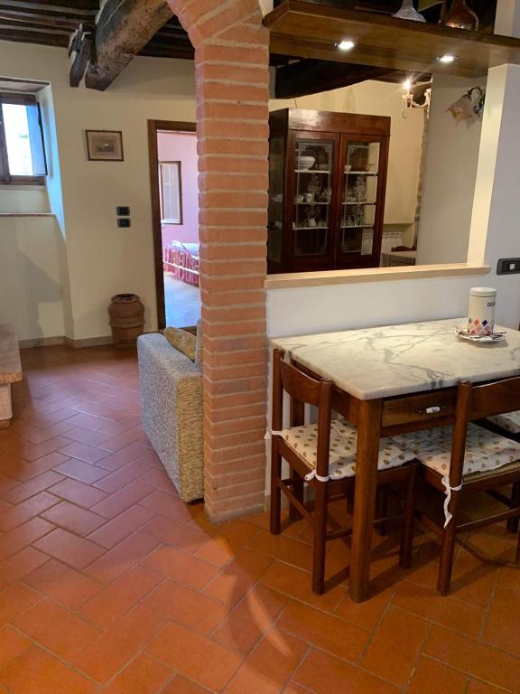 a dining room with a table and a chair at Casetta Campiglia d'Orcia in Campiglia dʼOrcia