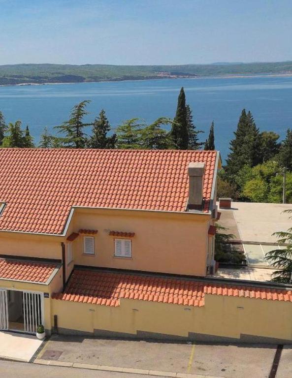 a house with a red roof with a view of the water at Apartman Rosi in Dramalj