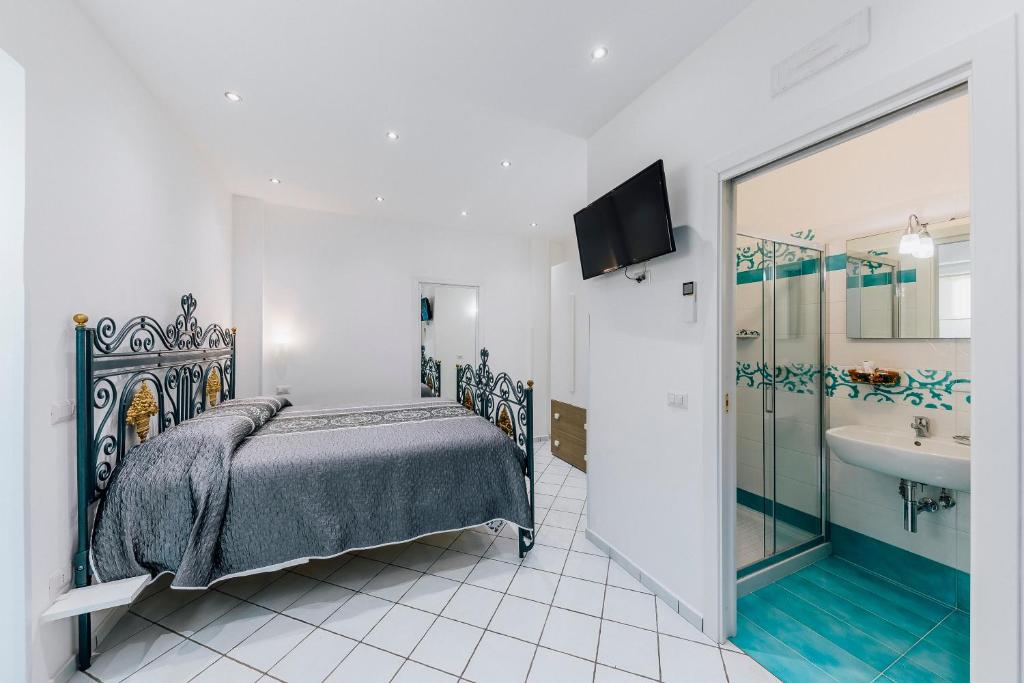 sypialnia z łóżkiem oraz łazienka z umywalką w obiekcie Gelsomino Rooms Ravello w mieście Ravello