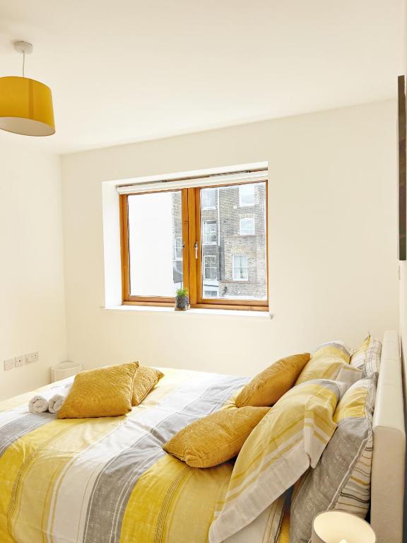 Hotel Lovely 1 bedroom apartment in South East London, a white bedroom with a bed with pillows on it at Lovely 1 bedroom apartment in South East London in London