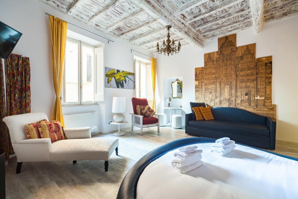 sala de estar con sofá azul y sillas en Trevi Art Suite en Roma