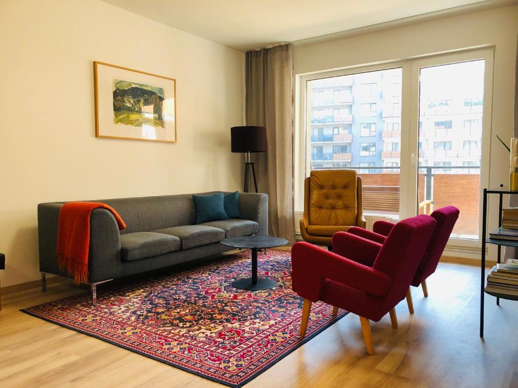 uma sala de estar com um sofá e duas cadeiras em Cosy design apartment in the city centre em Nitra