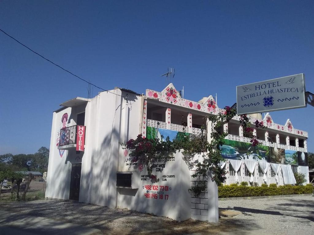 un edificio bianco con un cartello davanti di HOTEL ESTRELLA HUASTECA a Aquismón