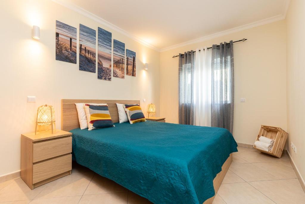 カバナス・デ・タビラにあるCasa do Afonso Cabanas Beachのベッドルーム1室(大型ベッド1台、青い毛布付)