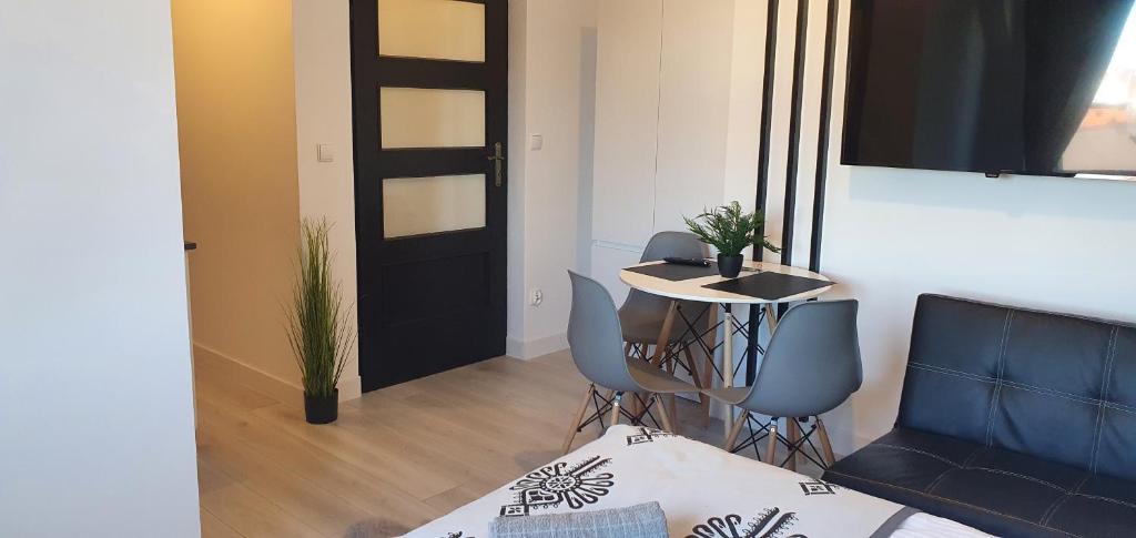 a room with a table and chairs and a black door at Apartamenty u Krysi 2 in Ząb