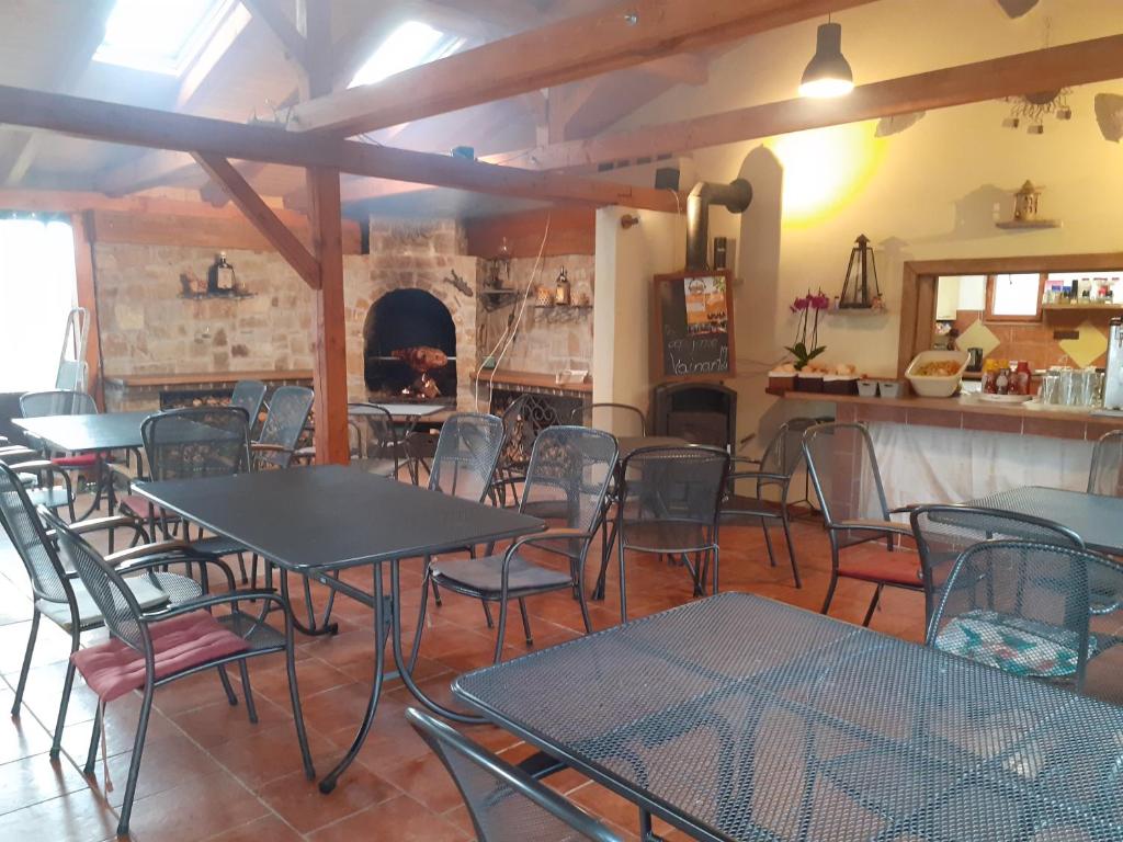 a dining room with tables and chairs and a fireplace at Apartmány Sluníčko in Nová Bystřice