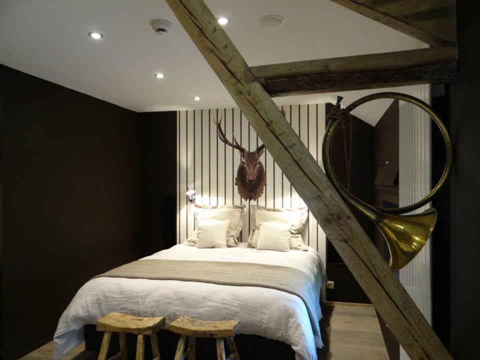 Dormitorio con cama con cabeza de ciervo en la pared en B&B Les Tilleuls, en Vielsalm