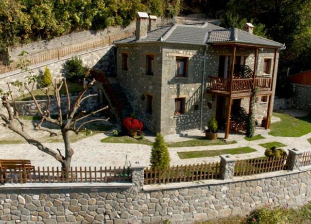 een groot huis met een stenen muur en een hek bij Πέτρινο Όραμα in Kotrónion