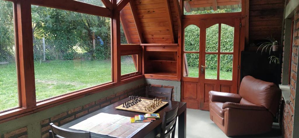 una habitación con un tablero de ajedrez sobre una mesa y una silla en Habitacion privada en cabaña compartida "Los Cordobeses" en San Martín de los Andes