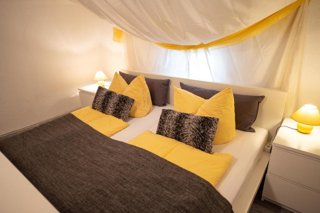 ein Schlafzimmer mit einem Bett mit gelben und grauen Kissen in der Unterkunft Ferienwohnung zur alten Post in Bad Grund