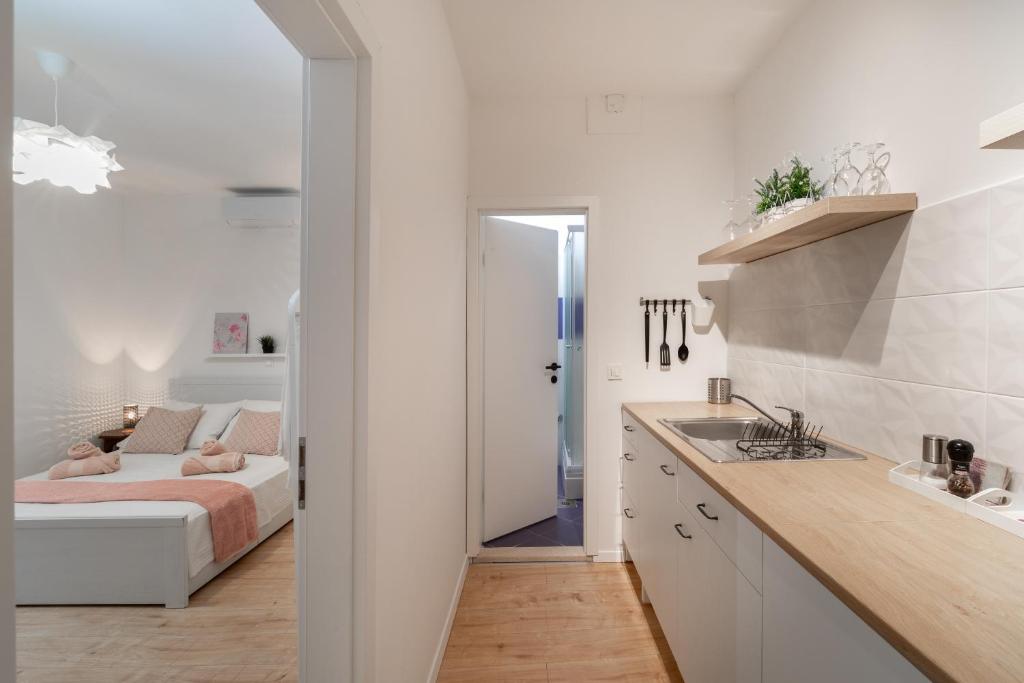 biała kuchnia z łóżkiem w pokoju w obiekcie Apartment Brandesa w Korčuli