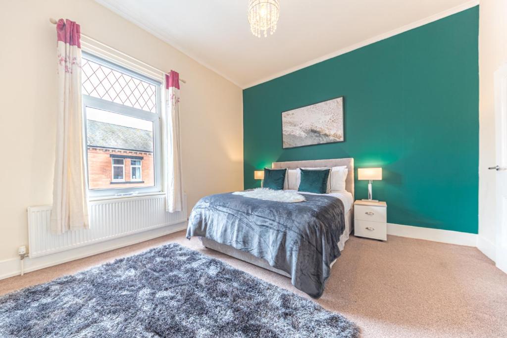 a bedroom with a bed and a blue wall at *KING BED* LUXURY CITY CENTRE HOUSE in Barrow in Furness