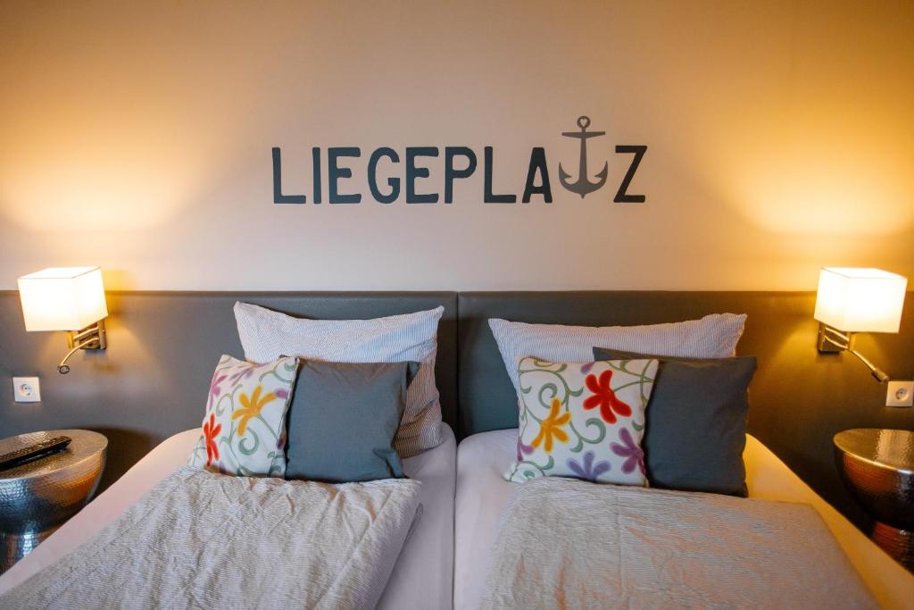a bedroom with two beds and a sign on the wall at Pension Mai-Scholle in Borkum