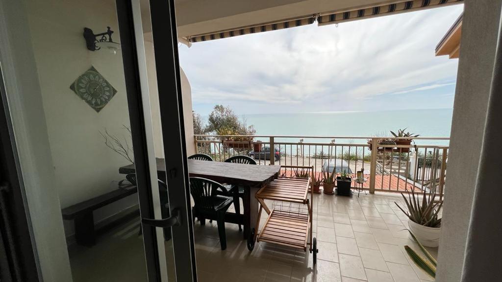 a patio with a table and chairs on a balcony at A'mare in Siculiana Marina