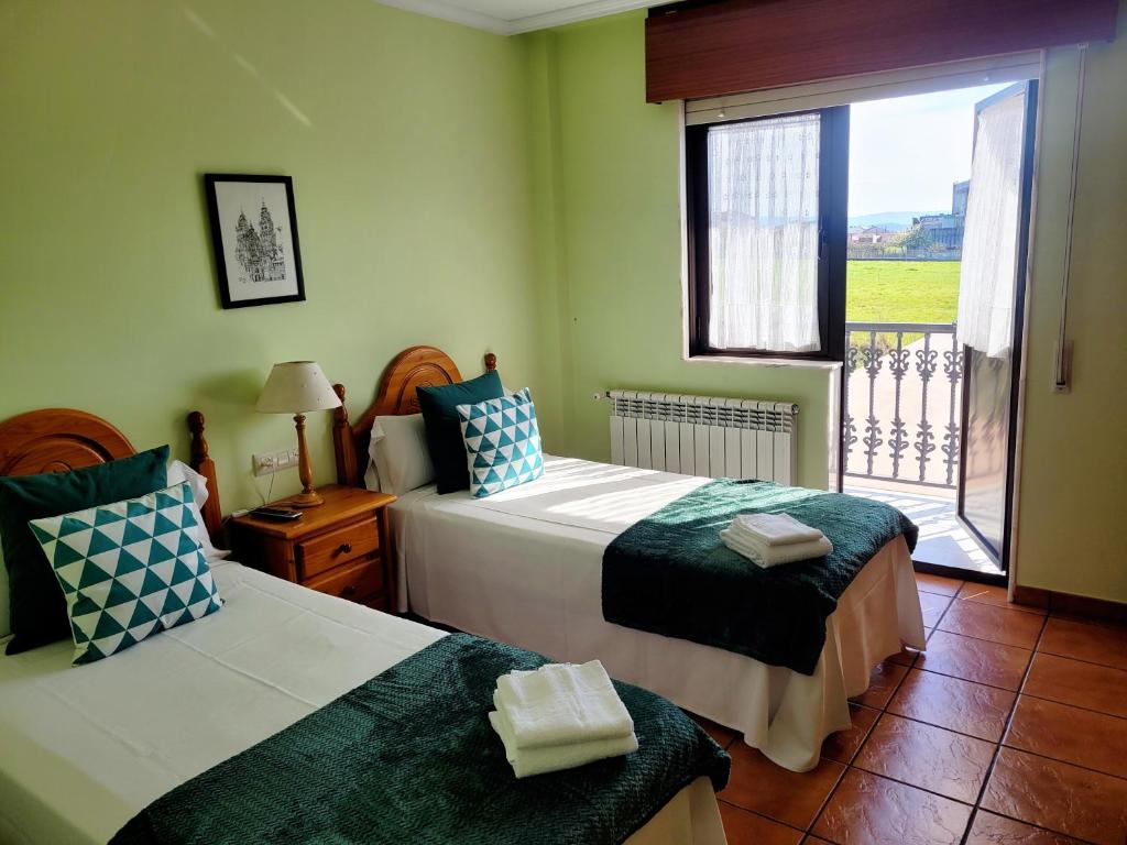 1 dormitorio con 2 camas y ventana con vistas en Vilariño Moscoso, en Arzúa