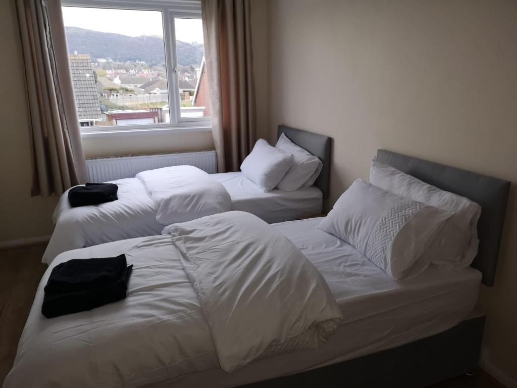 duas camas num quarto de hotel com uma janela em Ffrith House em Prestatyn