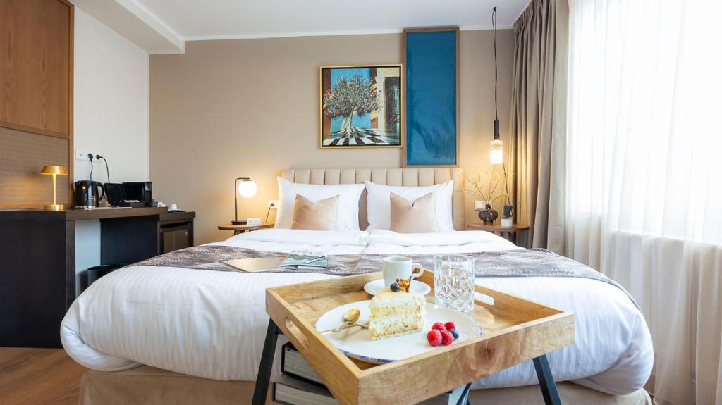 a hotel room with a bed with a tray of food at Delphi Hotel & Restaurant in Neu Wulmstorf