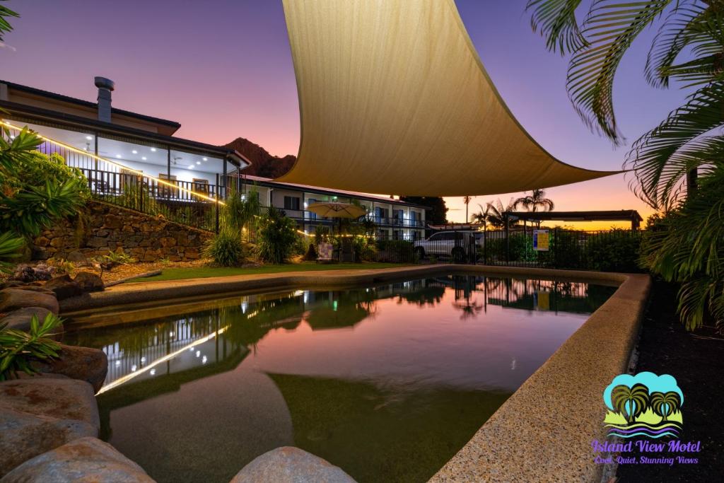 een huis met een zwembad voor een gebouw bij Island View Motel in Townsville