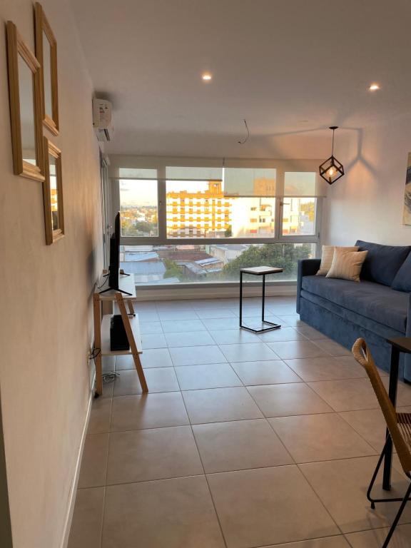 un soggiorno con un divano blu e un tavolo di Administración MAIPU 3B FI DEPTO PREMIUM a Tandil