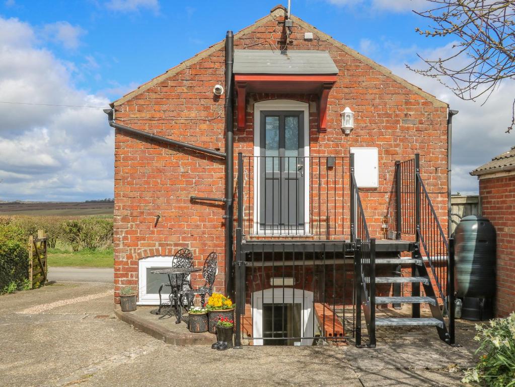 a small red brick house with a door and a staircase at The Granary in Great Driffield