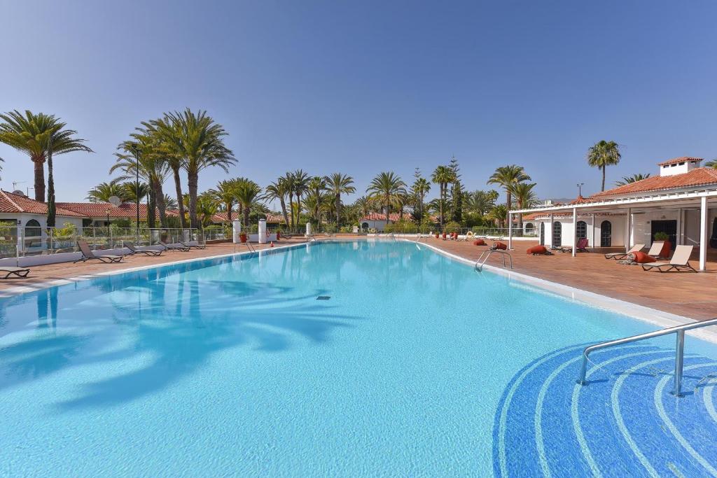 ein großer Pool in einem Resort mit Palmen in der Unterkunft Bungalow Sun Club EM259A by VillaGranCanaria in Playa del Ingles