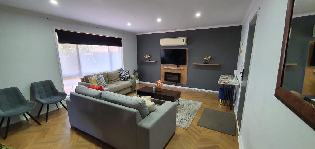 a living room with a couch and a table at Flamingo stay - Renovated 2-bed unit with BBQ & SPA ideal for holiday and business travel in Mildura