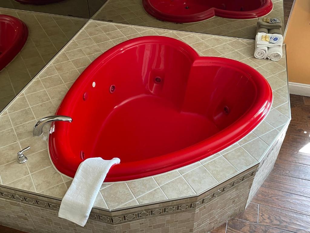 a red bath tub with a white towel in a bathroom at Sea Palace Inn in Seaside Heights