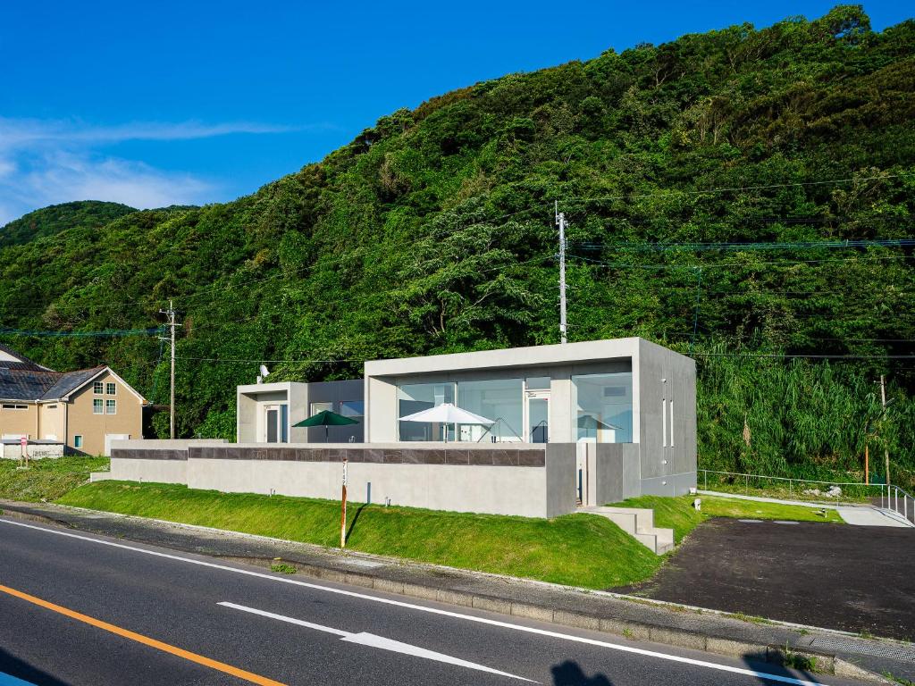 une maison sur le flanc d'une montagne dans l'établissement 天草三角シーサイドヴィラ, à Uki