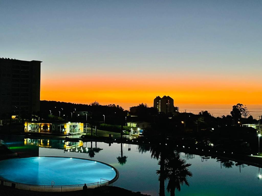 vista para uma piscina ao pôr-do-sol em Laguna Vista Algarrobo em Algarrobo