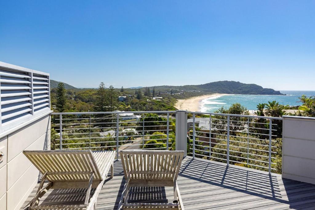 een balkon met twee stoelen en uitzicht op de oceaan bij Laaqua in Blueys Beach