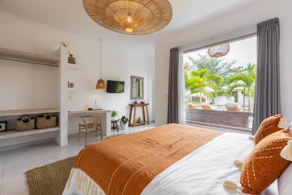 a bedroom with a large bed and a large window at Jepun Sari Uluwatu in Uluwatu