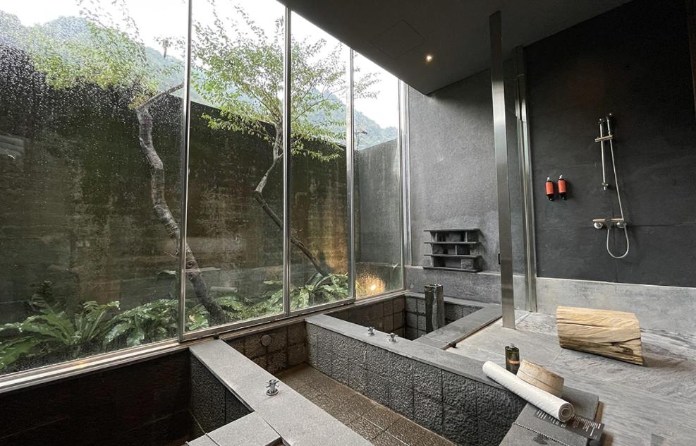 a bathroom with a shower and a large window at Onsen Papawaqa in Tai&#39;an