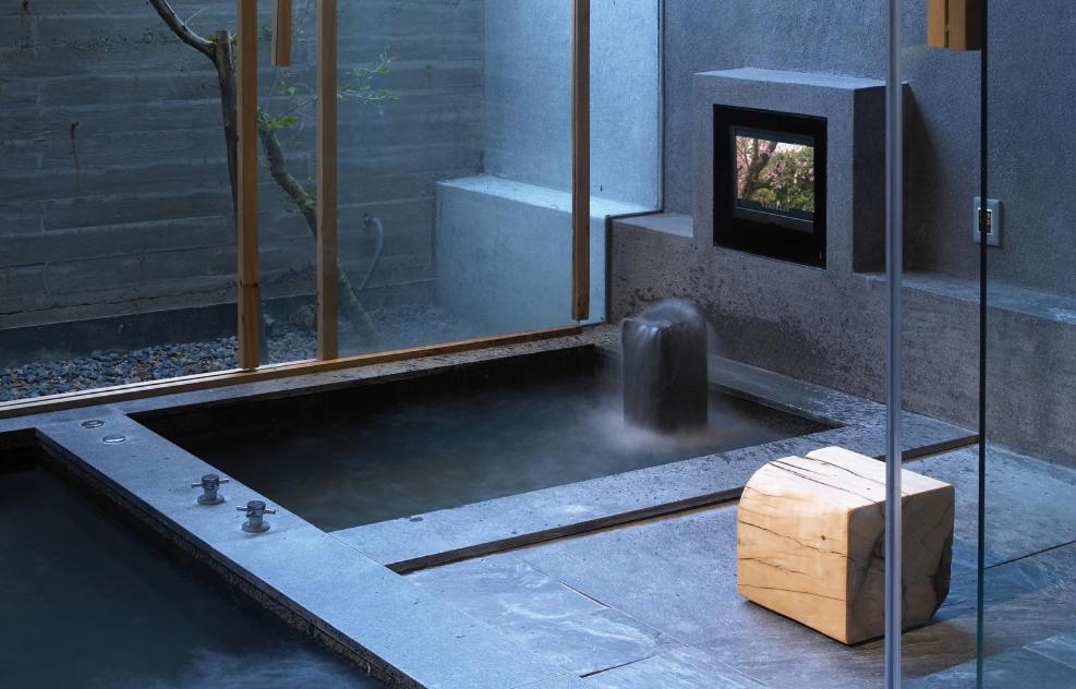 a bathroom with a bath tub with a fire place at Onsen Papawaqa in Tai&#39;an