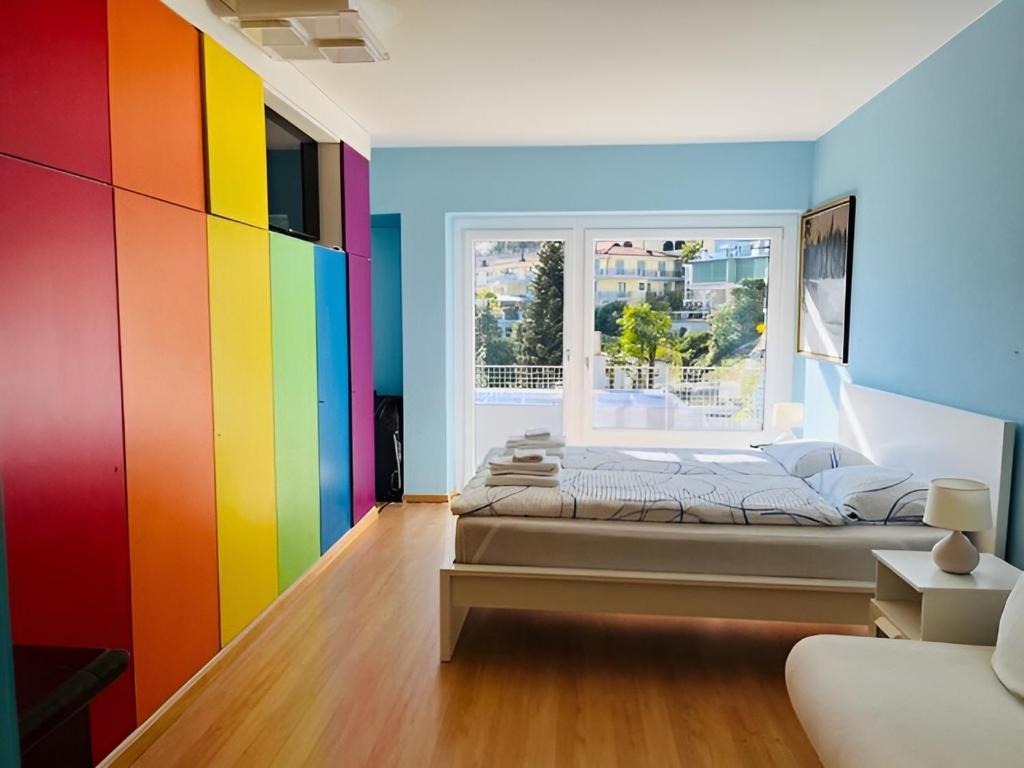 a bedroom with colorful walls and a bed with a window at Relax sul Lago Maggiore in Muralto