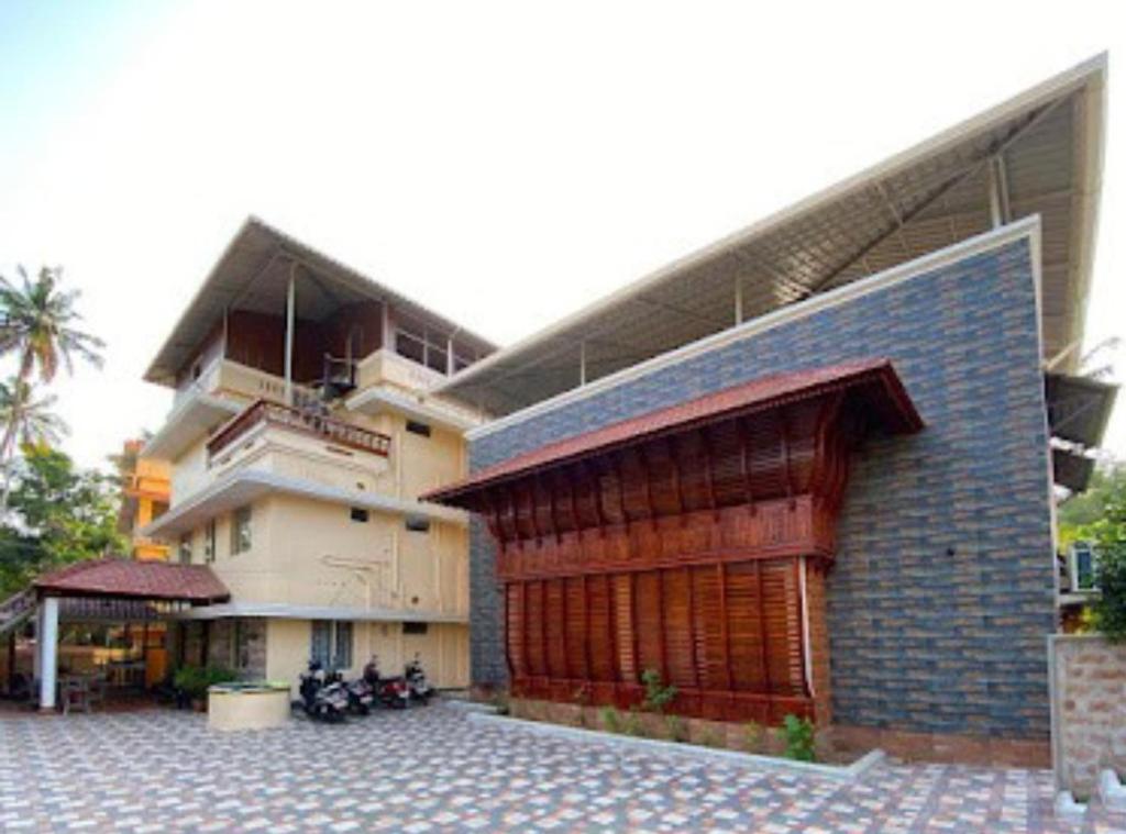 um edifício com um grande edifício com garagem em Coral Cove Beach Resort em Varkala