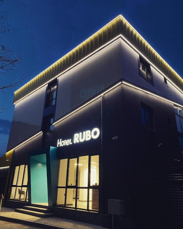 a black building with a hotel ruoco sign on it at RUBO Hotel in Shumen