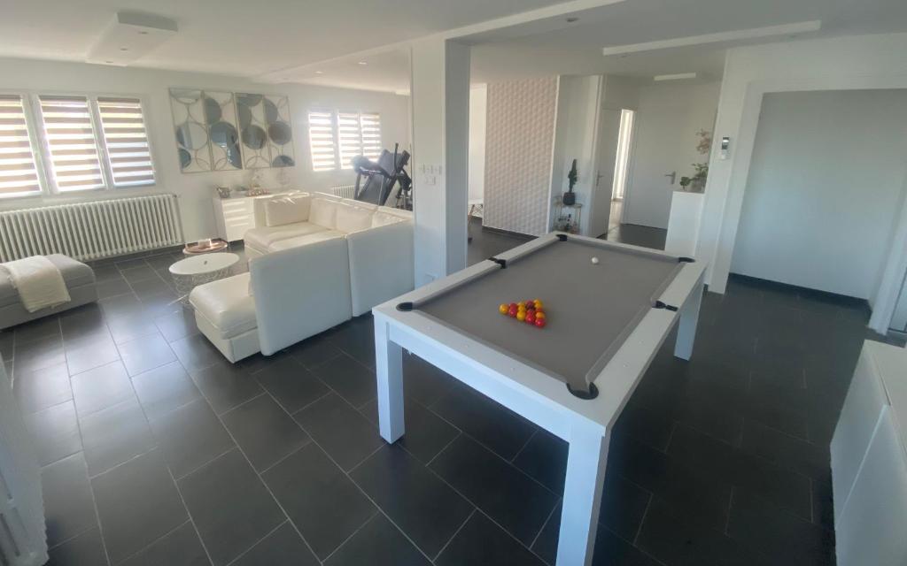 a living room with a pool table in the middle at Chambre dans logement partagé chez l habitant avec piscine de 1 à 3 chambres in Grièges