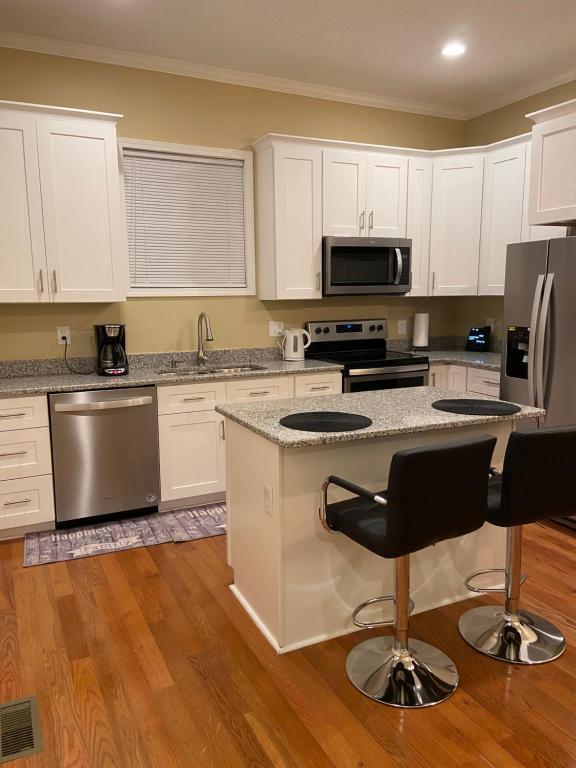 a kitchen with white cabinets and stainless steel appliances at Modern home with huge fenced yard and No pet fees in Durham