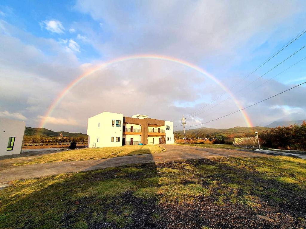 a rainbow in the sky over a house at Clare Holiday B&B in Checheng