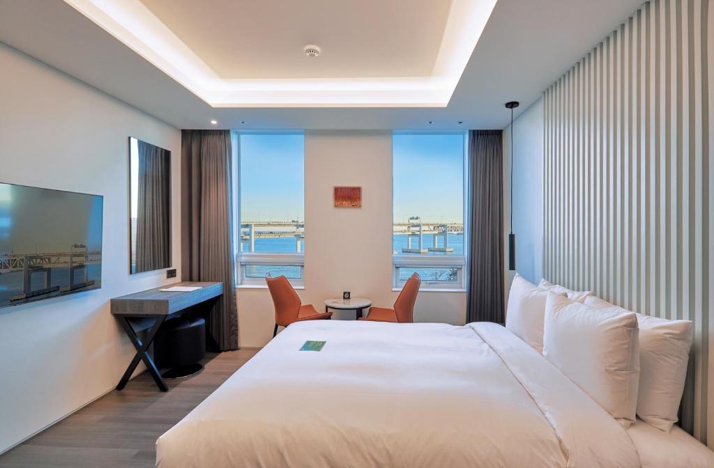 釜山にあるAG405 Hotelの大きなベッドと机があるホテルの部屋