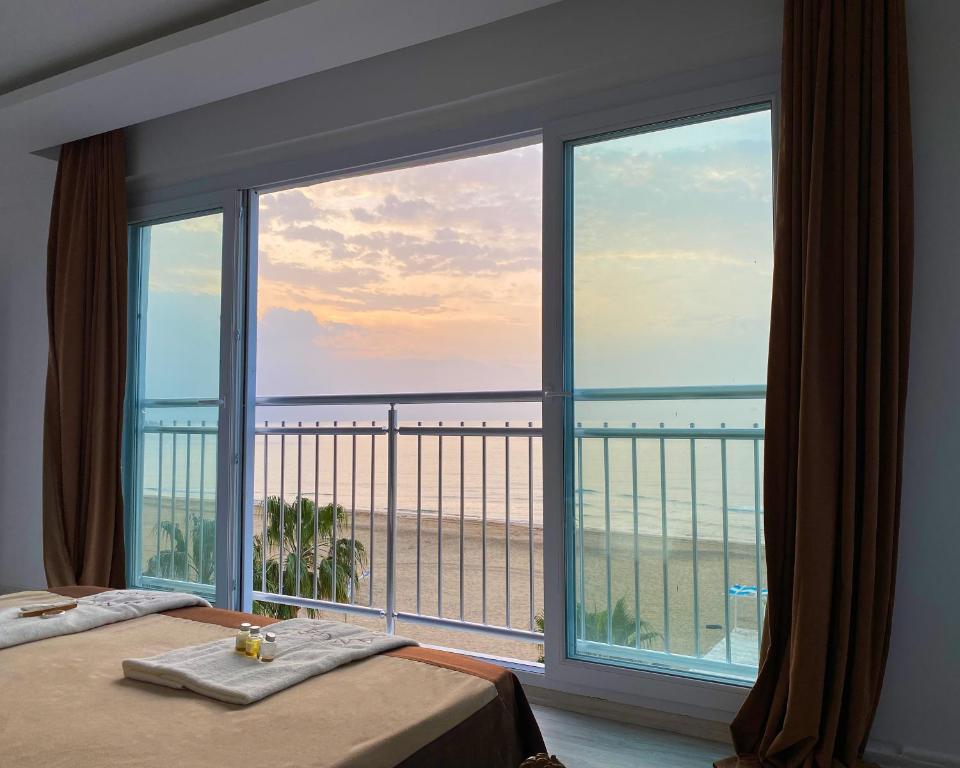 1 dormitorio con ventana grande con vistas al océano en Angel Beach Hotel Kızkalesi Mersin, en Erdemli