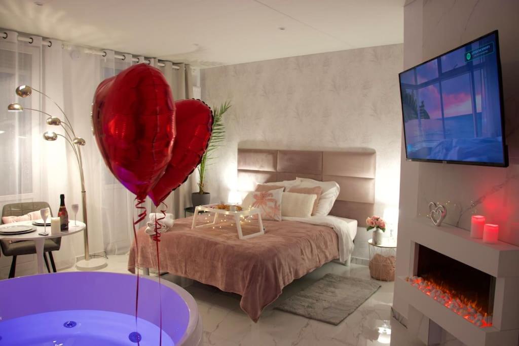 um quarto com uma cama grande e um balão vermelho em SPA Romantique ... Esprit LOVE em Mulhouse