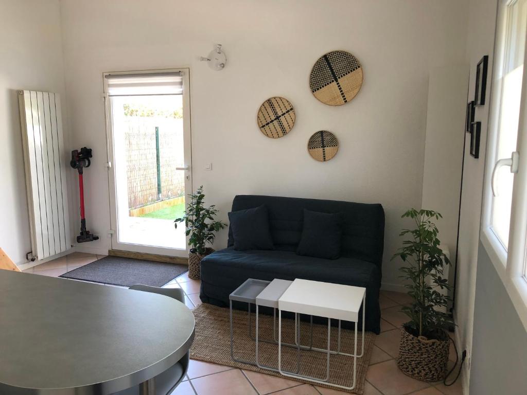 a living room with a blue couch and a table at L'instant d'une pause Studio mezzanine avec jardin proche Montpellier in Teyran