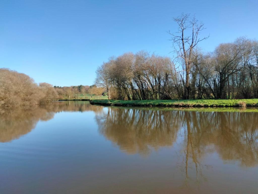 vistas a un río con árboles en el fondo en Hébergement canal, en Villeder